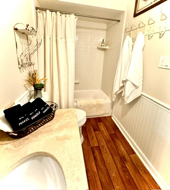 Second full bathroom with a vintage chandelier and warm wood floors