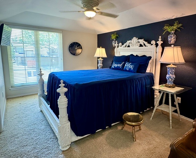 A guest bedroom with a carved white bed frame against a deep accent wall