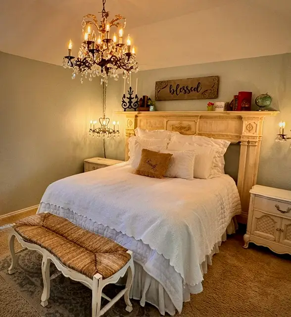Bedroom bathed in candlelight from a crystal chandelier