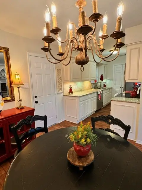 Fresh floral centerpiece on the dining table beneath warm chandelier light