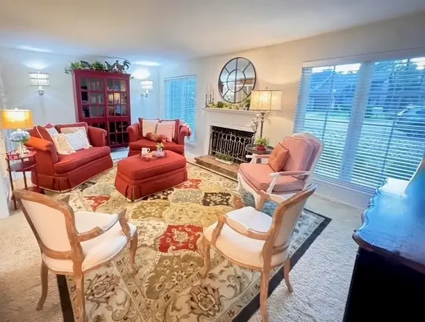 The living room at The Rustic Chandelier, with red loveseats, an antique bookcase and a gas fireplace